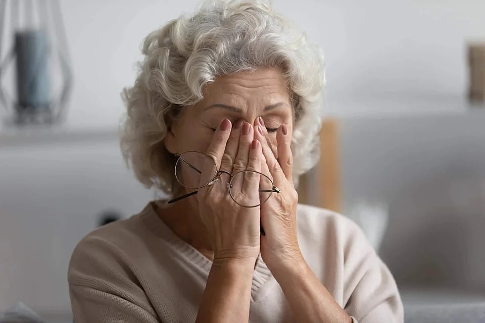 Ältere Frau hält sich die Hände vor das Gesicht